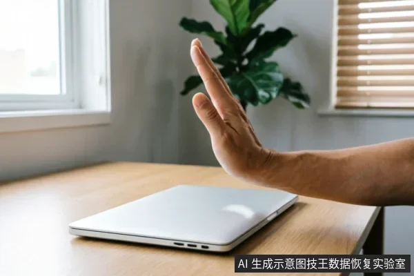 一只手掌在闭合的银色笔记本电脑前做出明确的停止手势,示意拒绝或暂停。背景为木质桌面、窗户及绿植,光线明亮,画面简洁,直观传达出“立即停止操作”的警示含义。